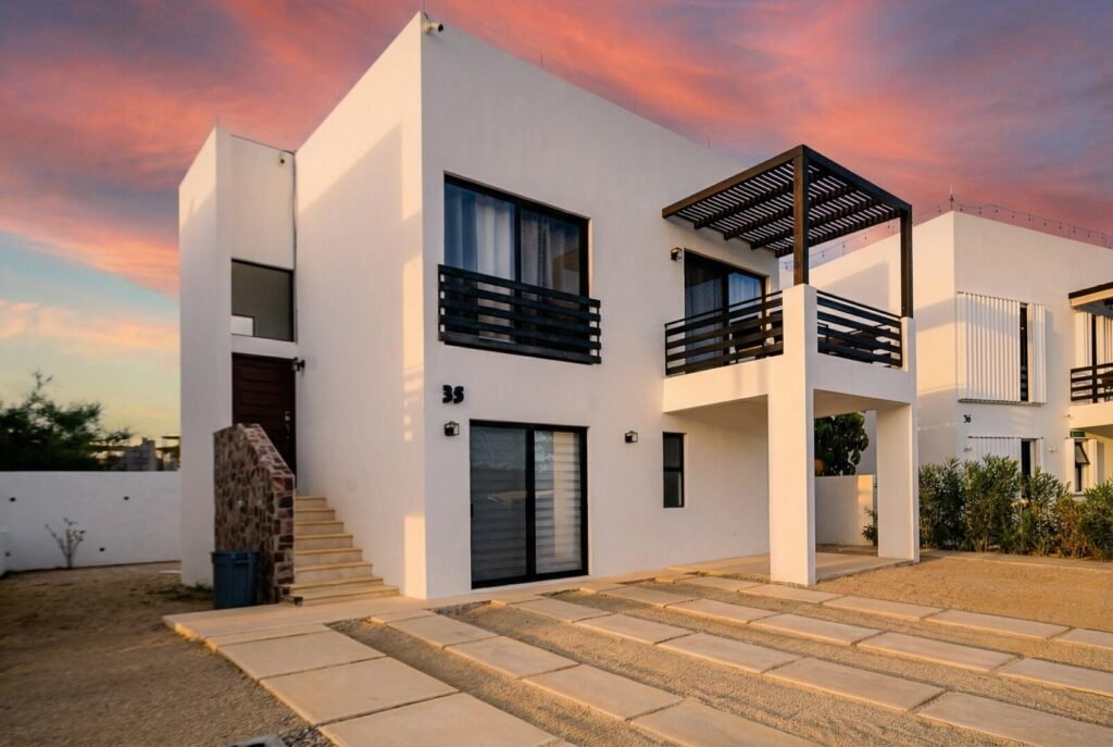 Los Cabos Casa Mex-Agaves Situated within the Casa Mexicana - Agaves community, this thoughtfully designed three-bedroom residence offers a functional and well-planned layout. The main level features a bedroom with an en-suite bathroom and walk-in closet, ideal for guests, multigenerational living, or those seeking stair-free access.A spacious outdoor terrace on the first floor, surrounded by tropical landscaping, provides a serene setting for both relaxation and entertaining. With multiple seating areas, it stands out as a unique feature within Casa Mexicana. The upper level includes two additional bedrooms, each with en-suite bathrooms and walk-in closets, along with the home's main living and kitchen areas. The indoor spaces are seamlessly connected to an additional terrace, enhancing the home's indoor-outdoor living appeal.Additional features include a dedicated laundry area, a two-car garage, and accordion-style hurricane shutters, combining comfort with practicality and peace of mind. – 521 ISLA NATIVIDAD, Cabo Corridor, BS